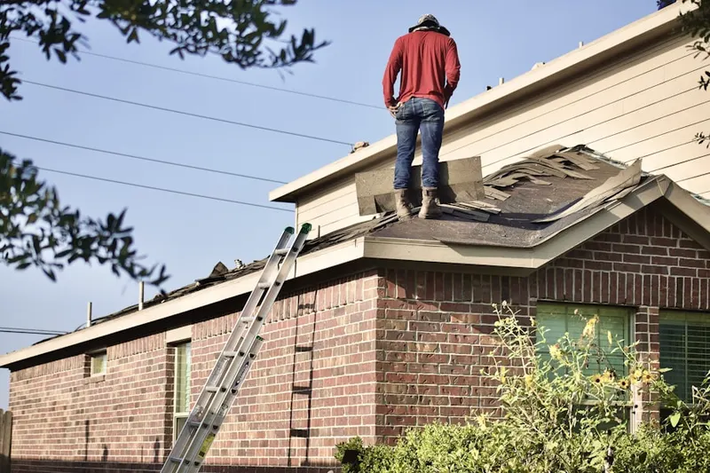 Professional roofer working on a residential roof in Hardistonville